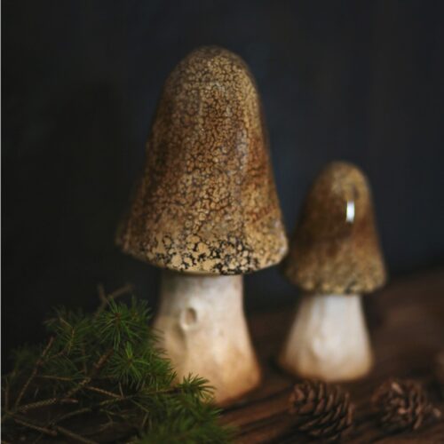 Två dekorationssvampar i keramik på bord, höstdekoration